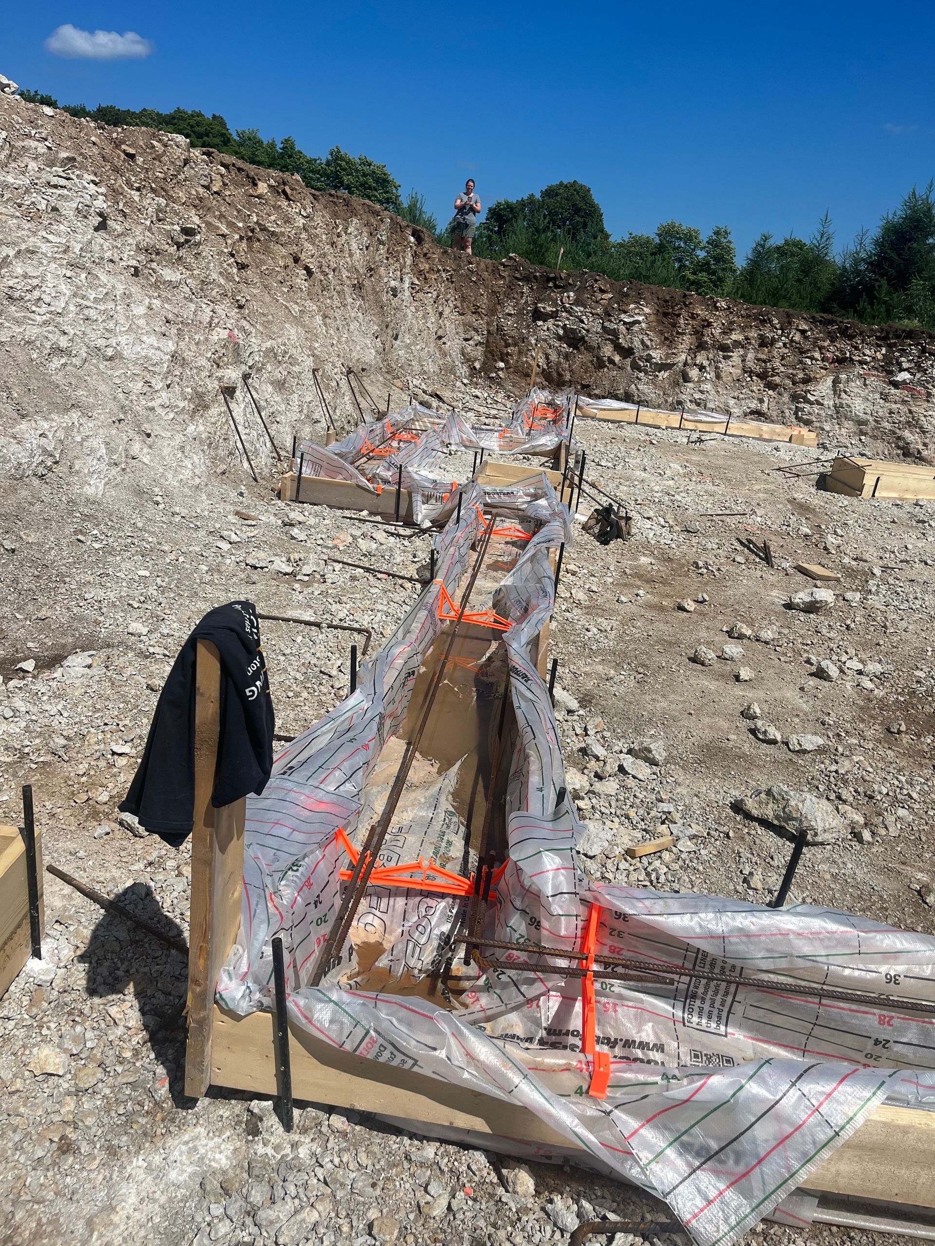 A person is standing in a pile of rocks in a construction site.