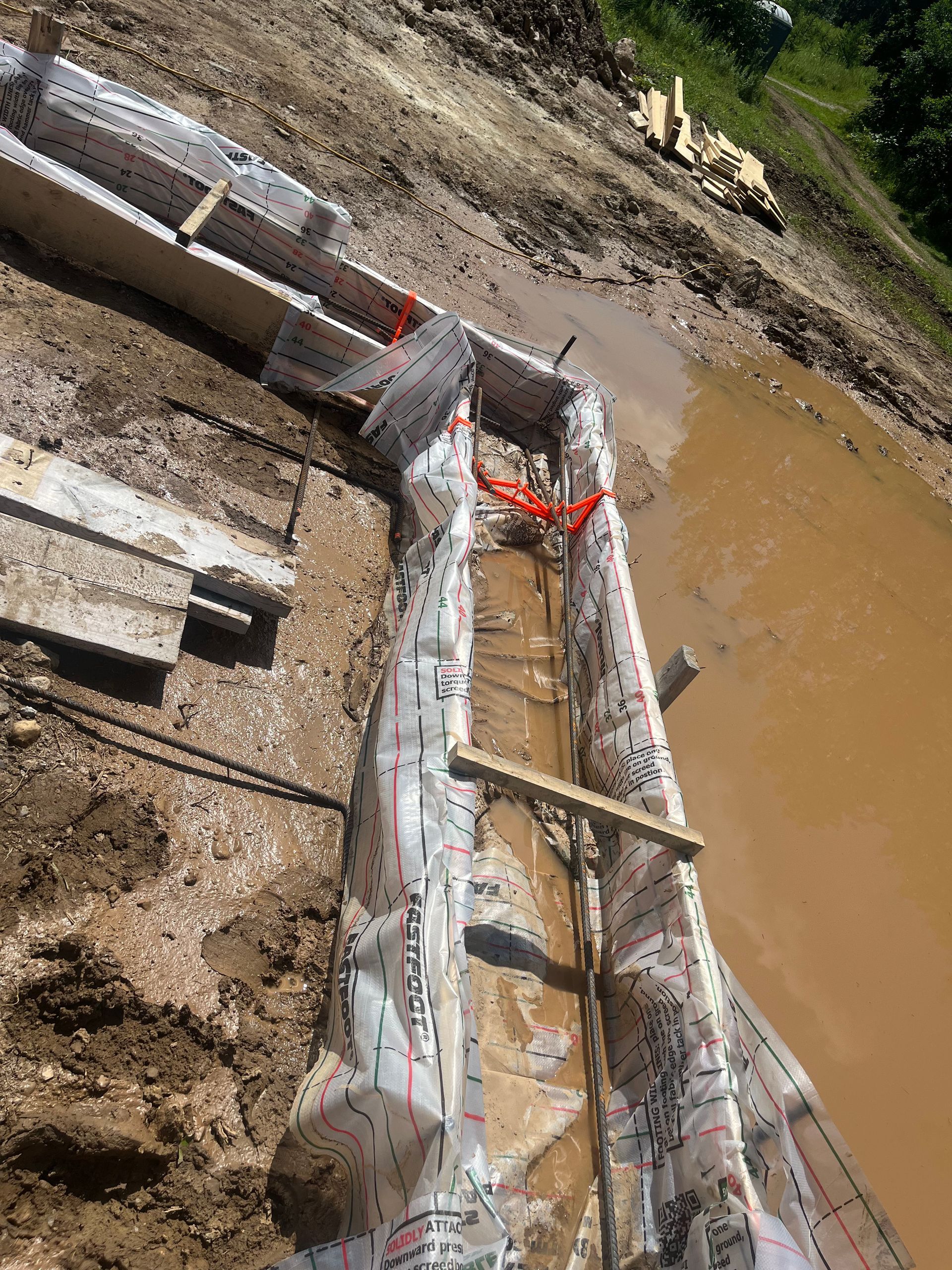 A boat is sitting in the mud next to a body of water.