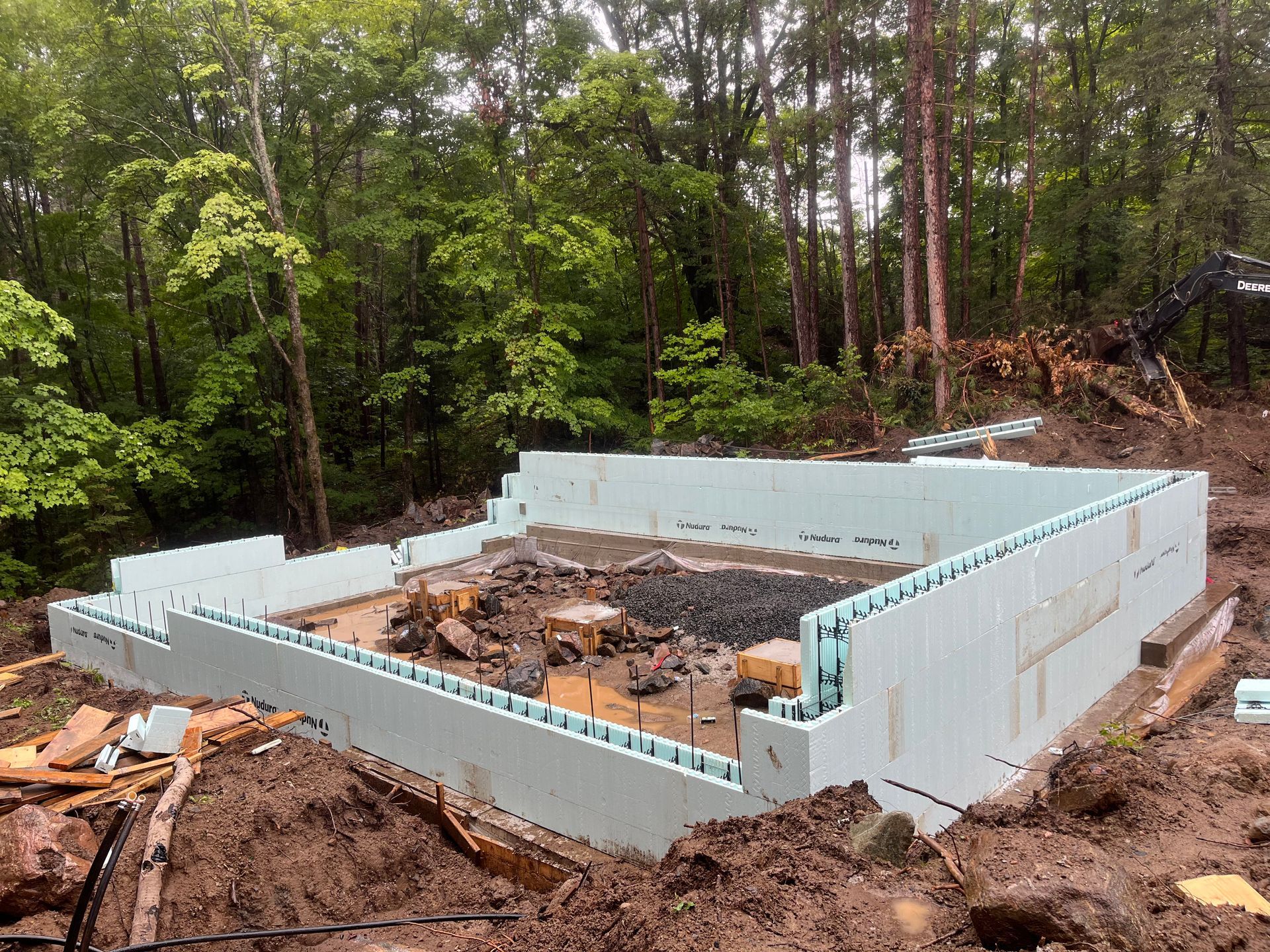 A large foundation is being built in the middle of a forest.