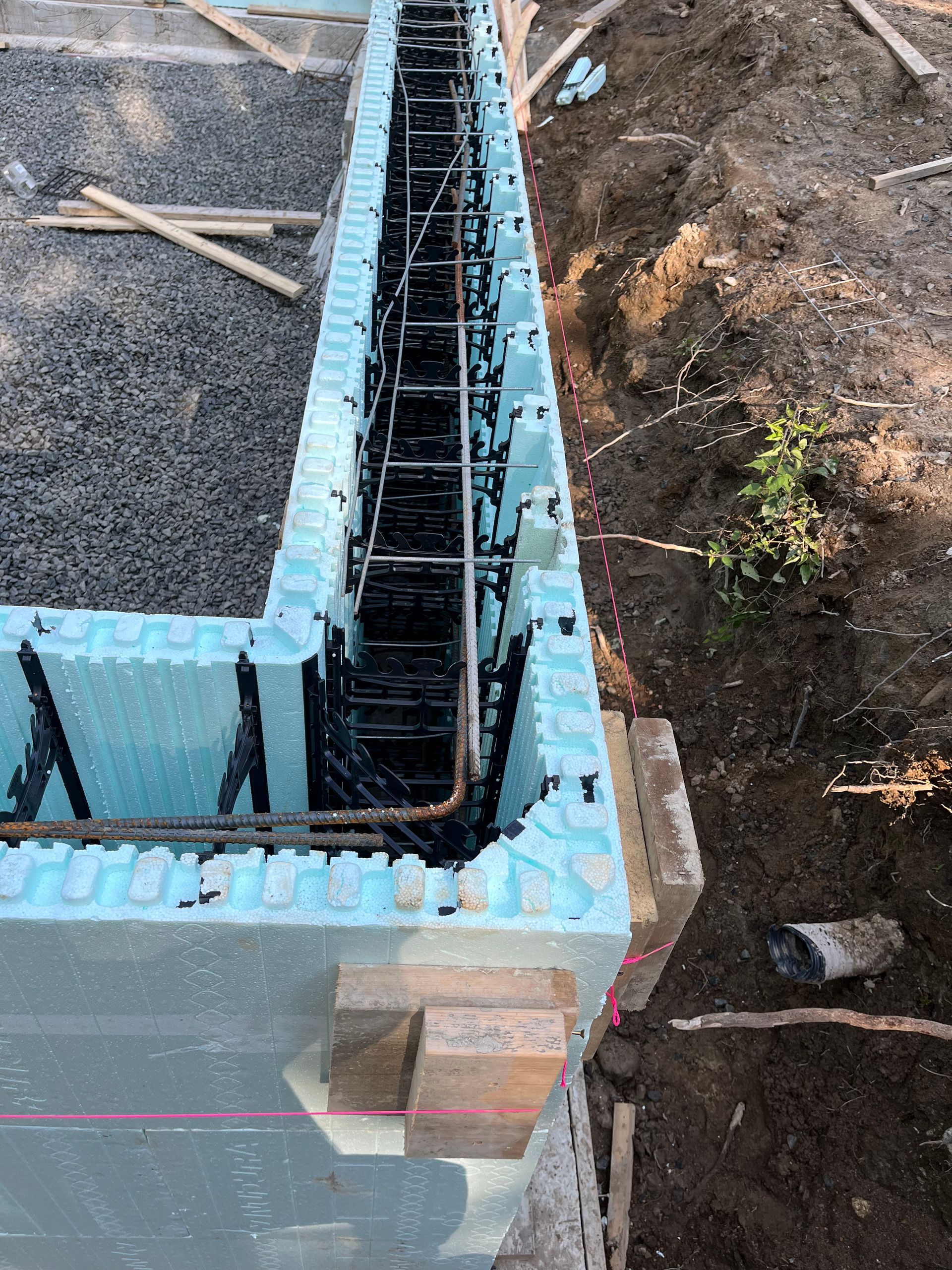 A concrete wall is being built with foam blocks and steel bars.