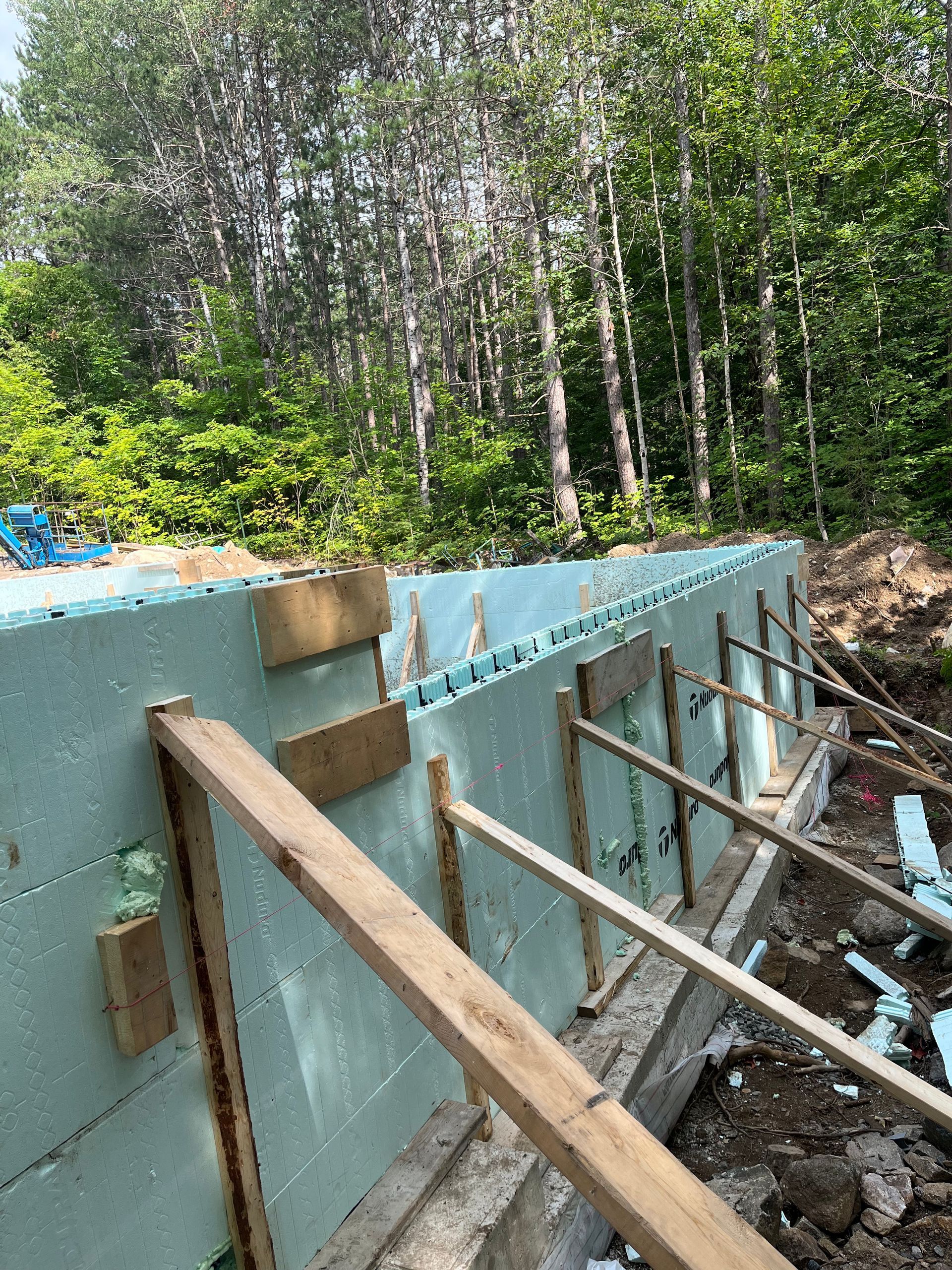 A large wall is being built in the middle of a forest.