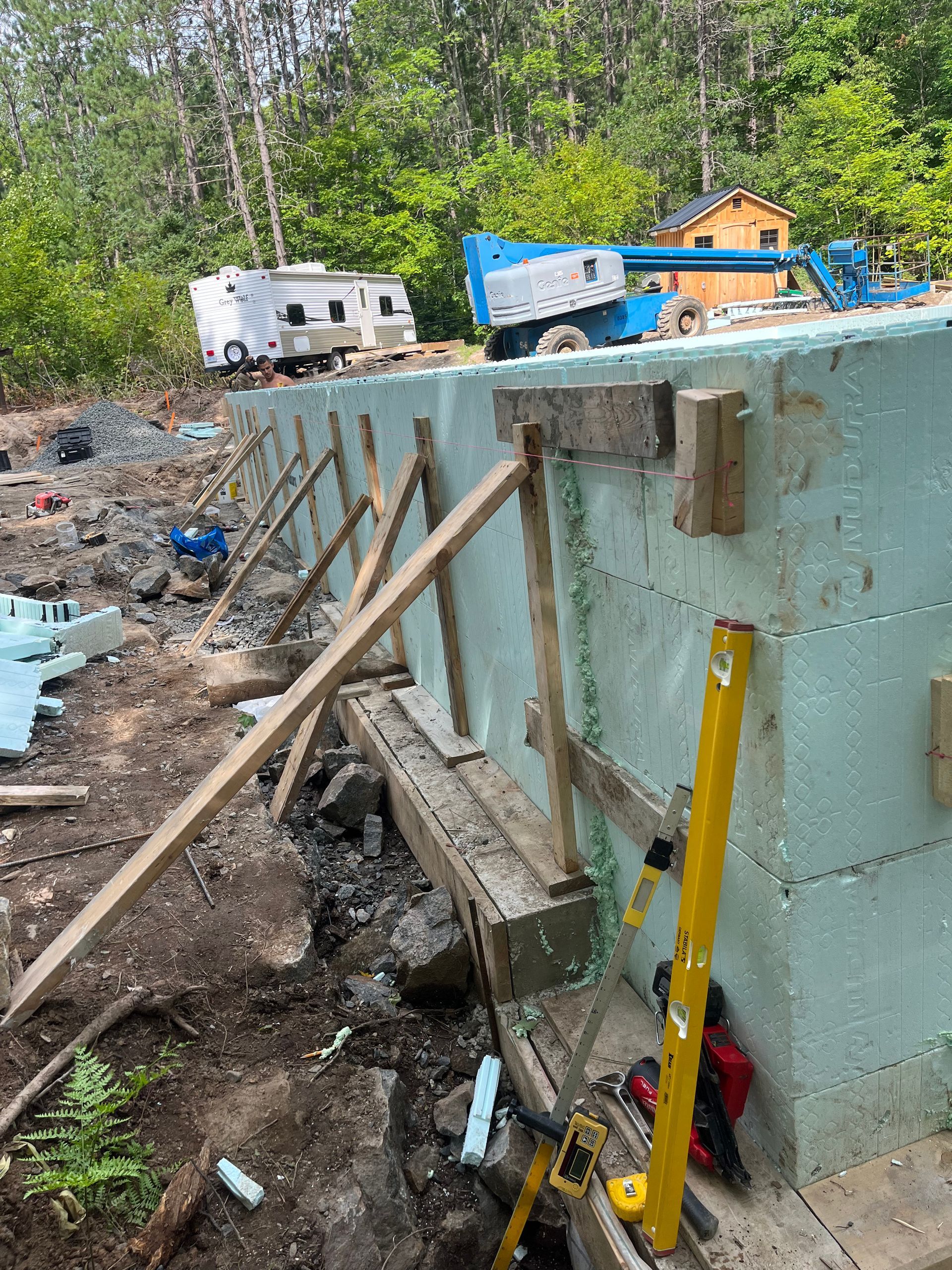 A concrete wall is being built in a backyard.