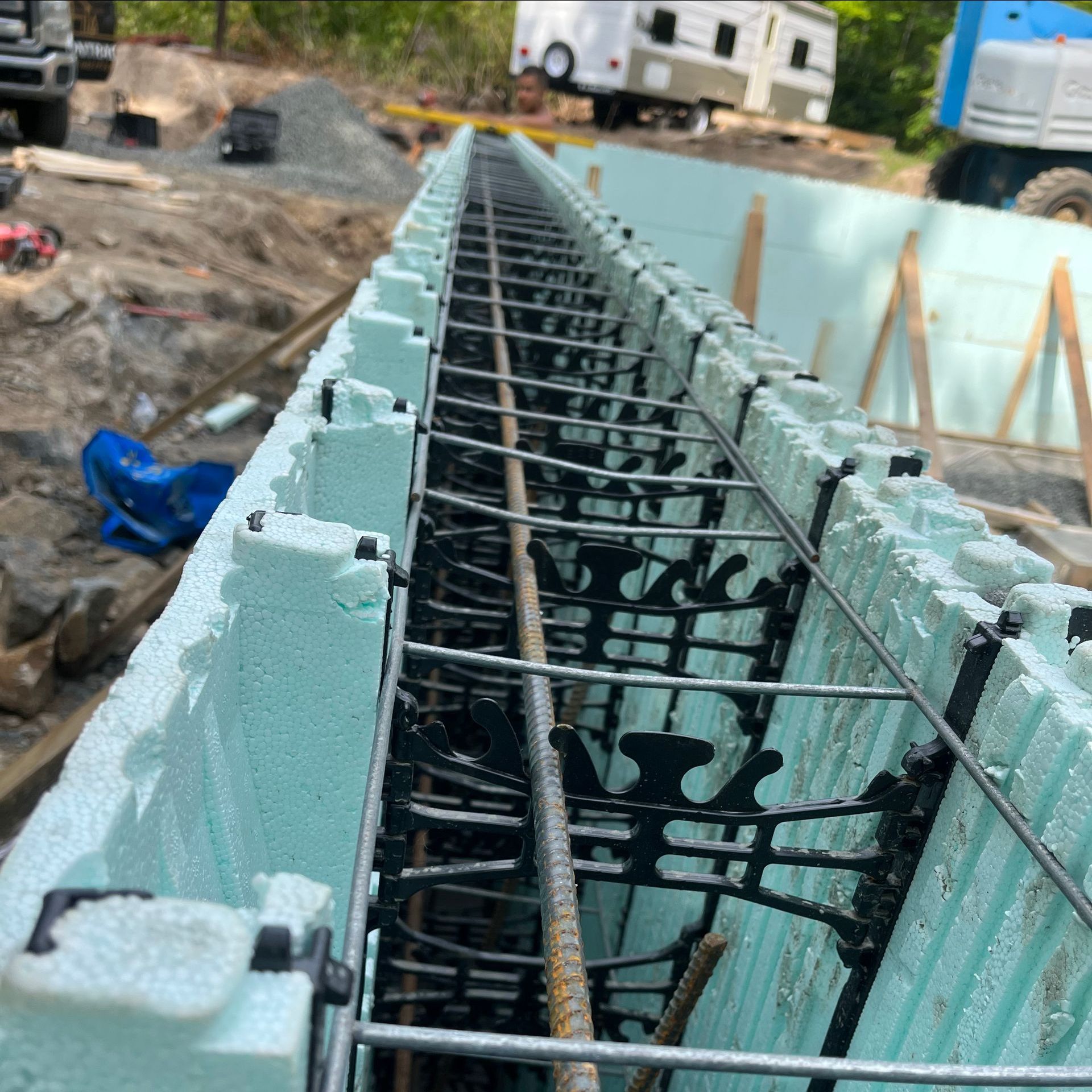 A concrete wall is being built with a truck in the background