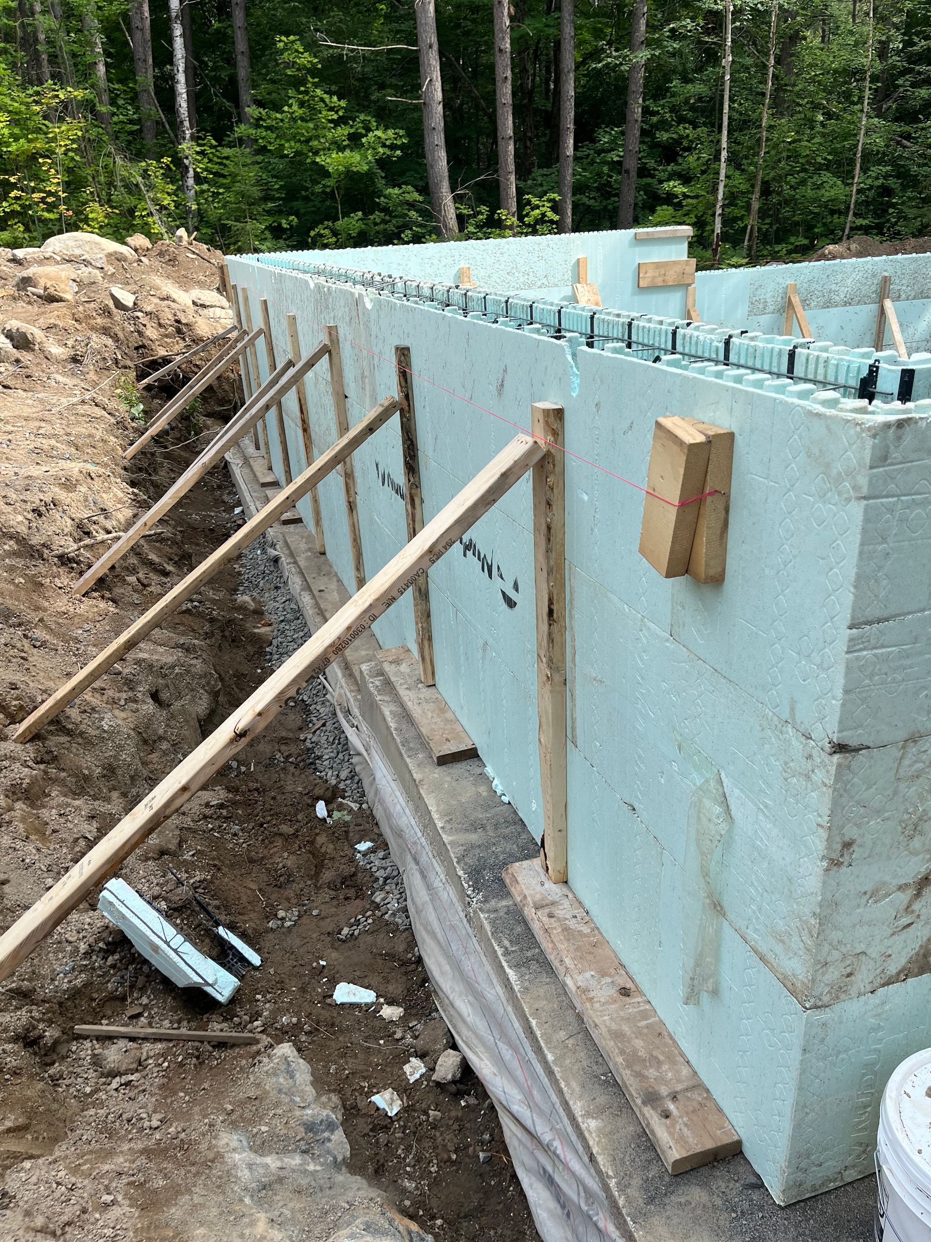 A wall is being built with foam blocks and wooden beams.