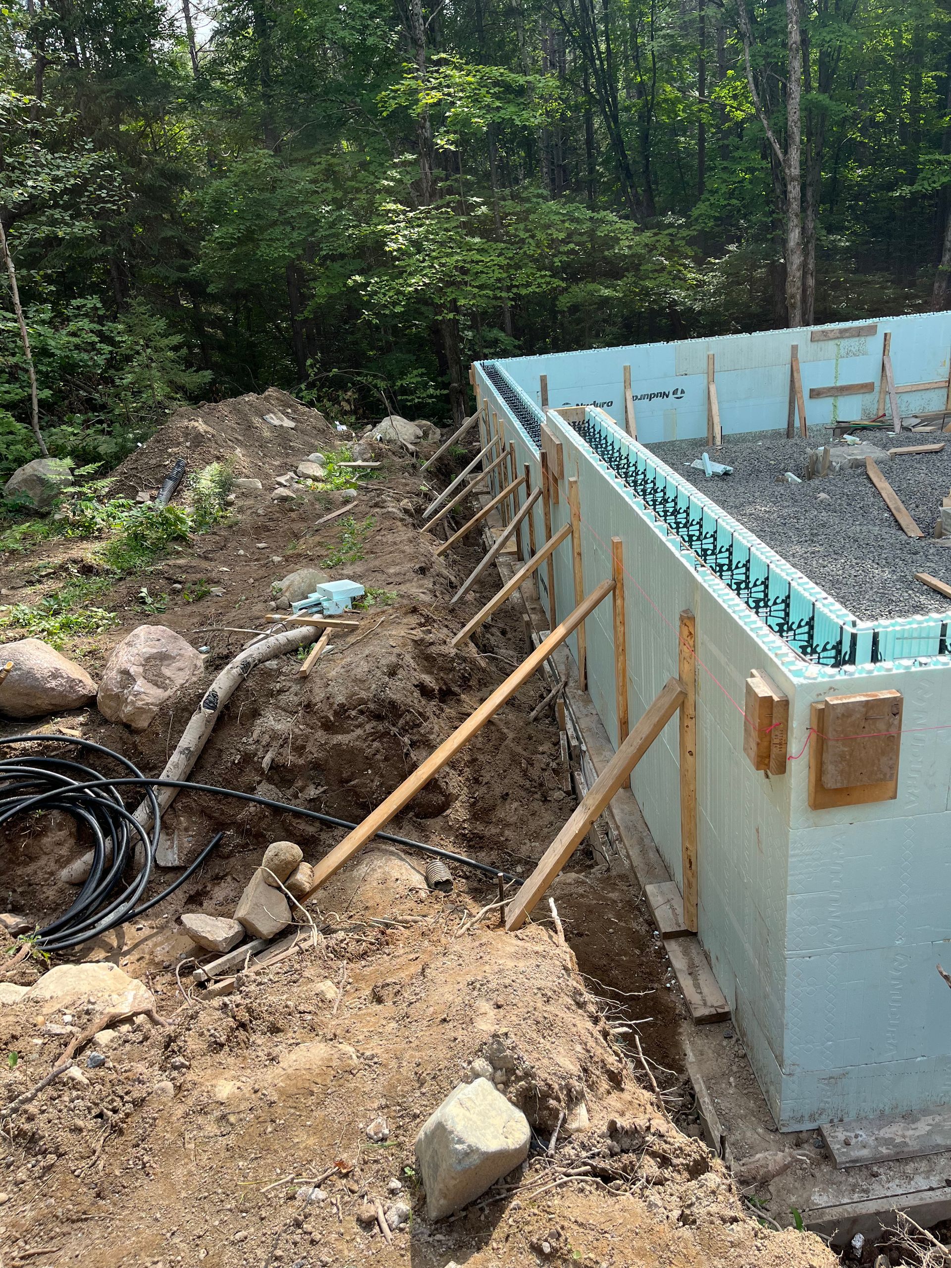 A concrete wall is being built in the middle of a forest.