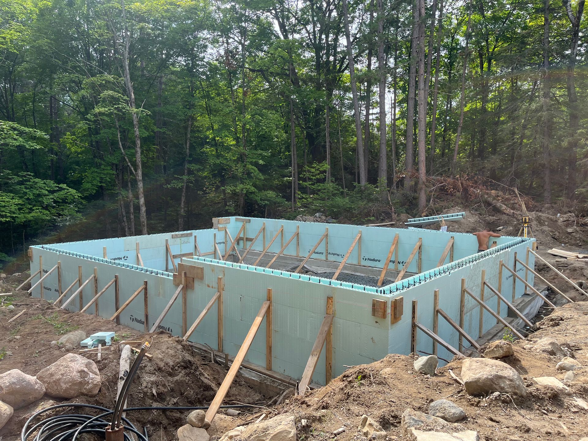 A swimming pool is being built in the middle of a forest.