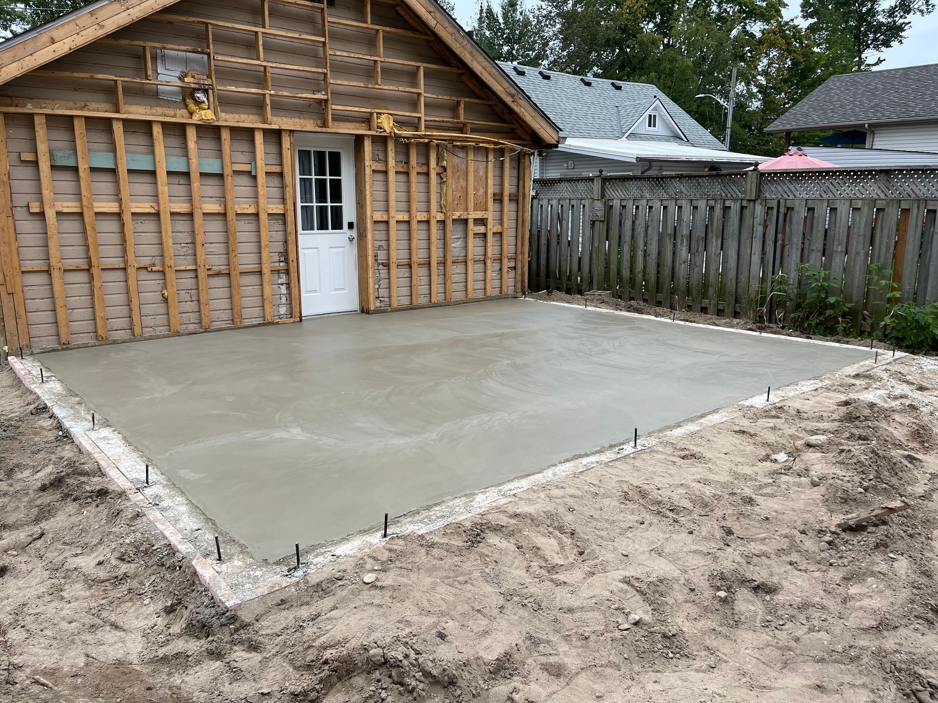 A concrete driveway is being built in front of a garage.