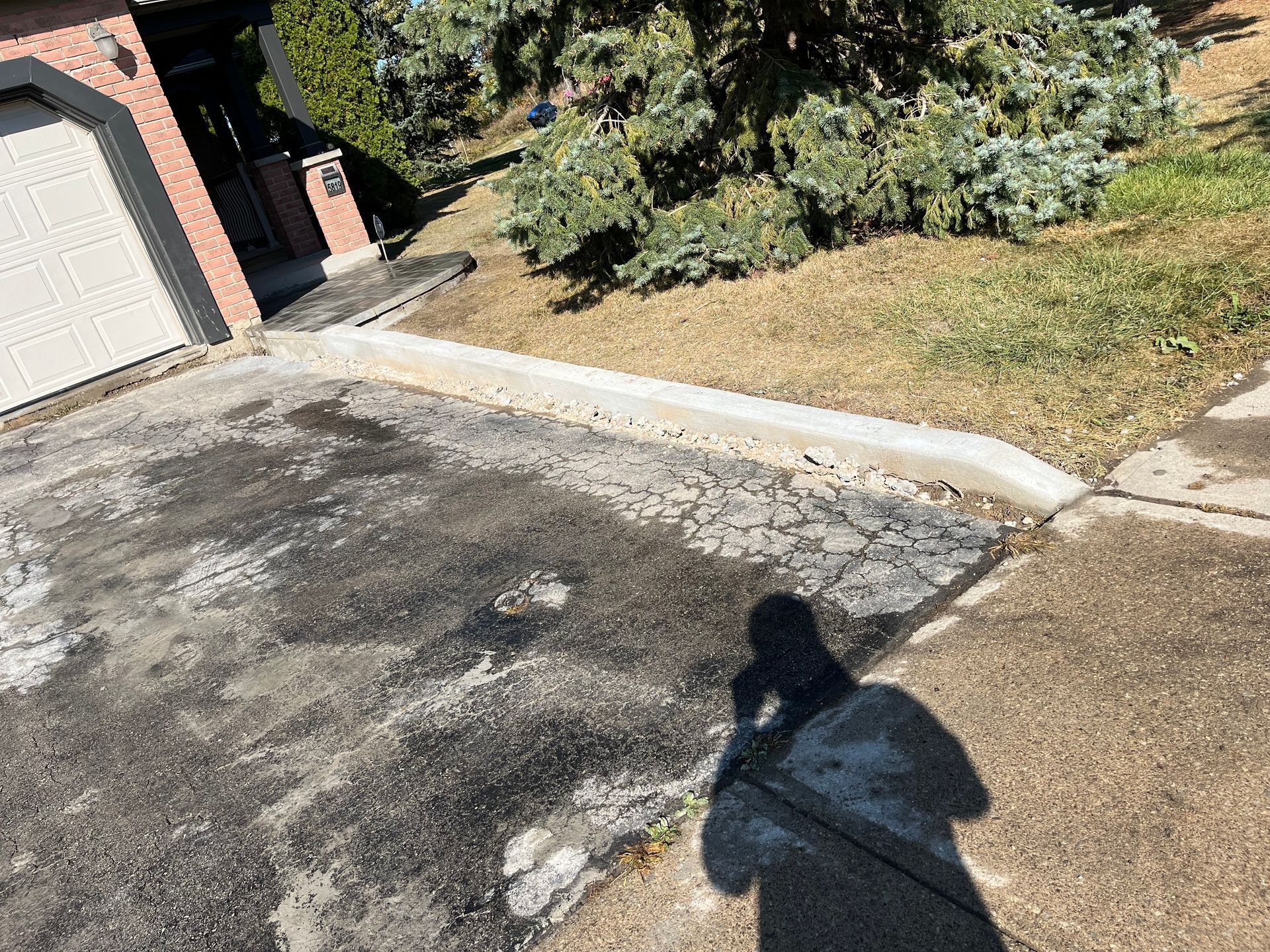 A person is cleaning a driveway with a pressure washer.