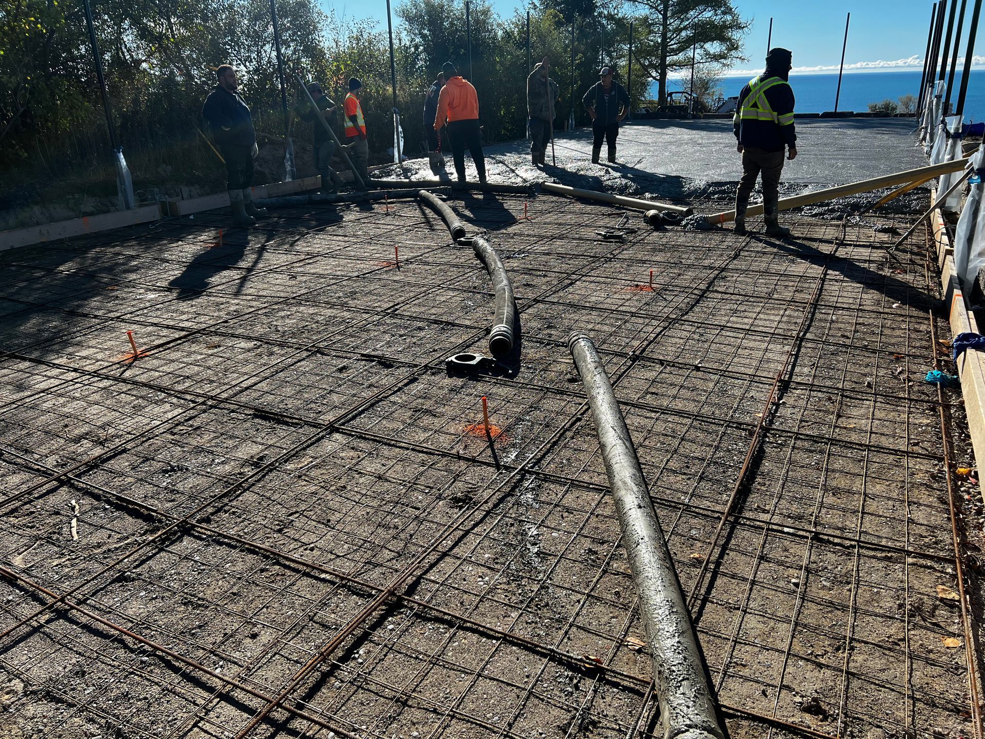 A group of construction workers are working on a concrete floor.