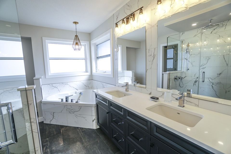 A bathroom with two sinks , a tub and two mirrors.