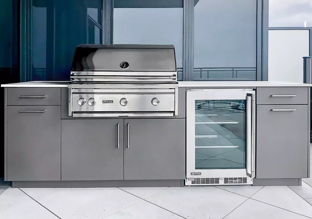 A kitchen with a grill and a refrigerator in it