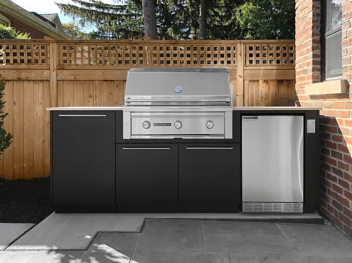 There is a grill and a refrigerator in the backyard.