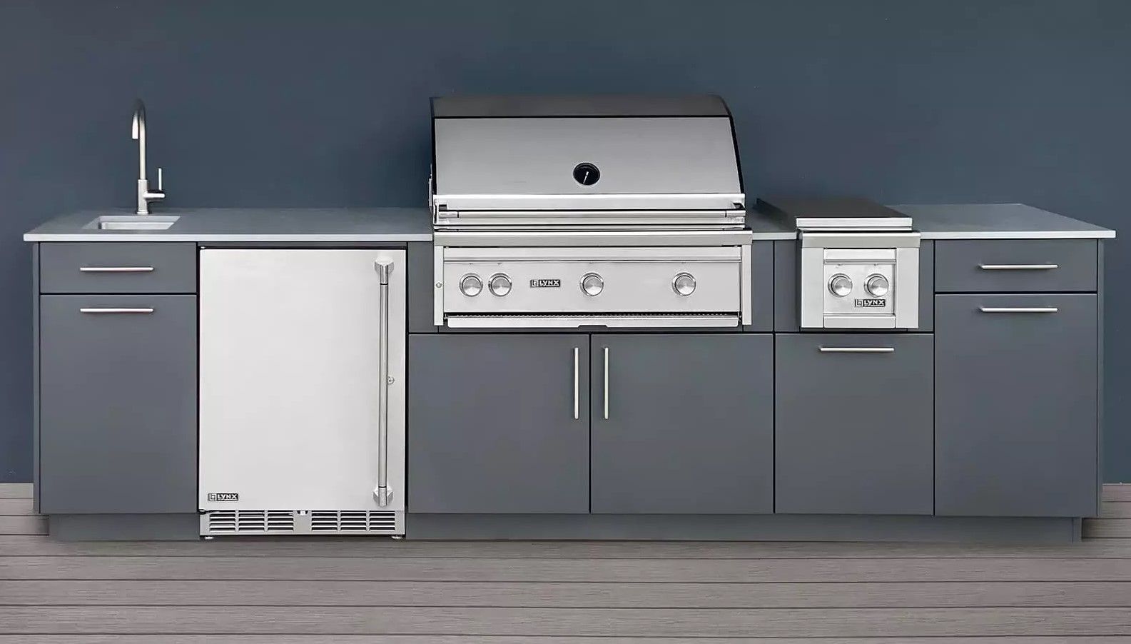 A kitchen with a grill , sink , and refrigerator