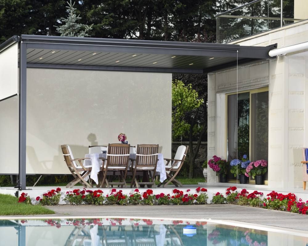 A patio with a table and chairs next to a pool