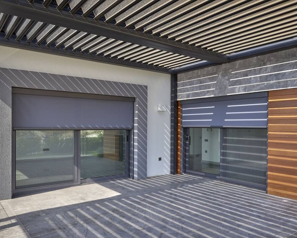 A modern house with a pergola and sliding glass doors.