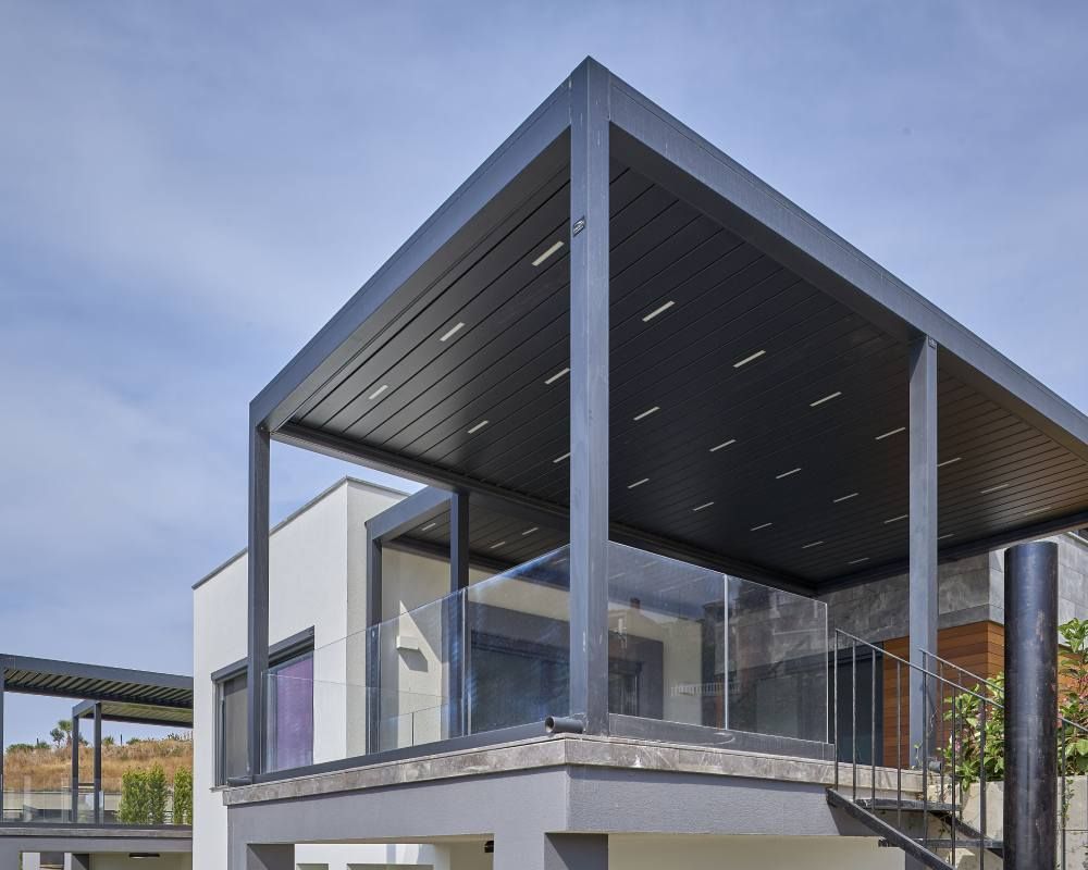 A house with a balcony and a pergola on top of it.