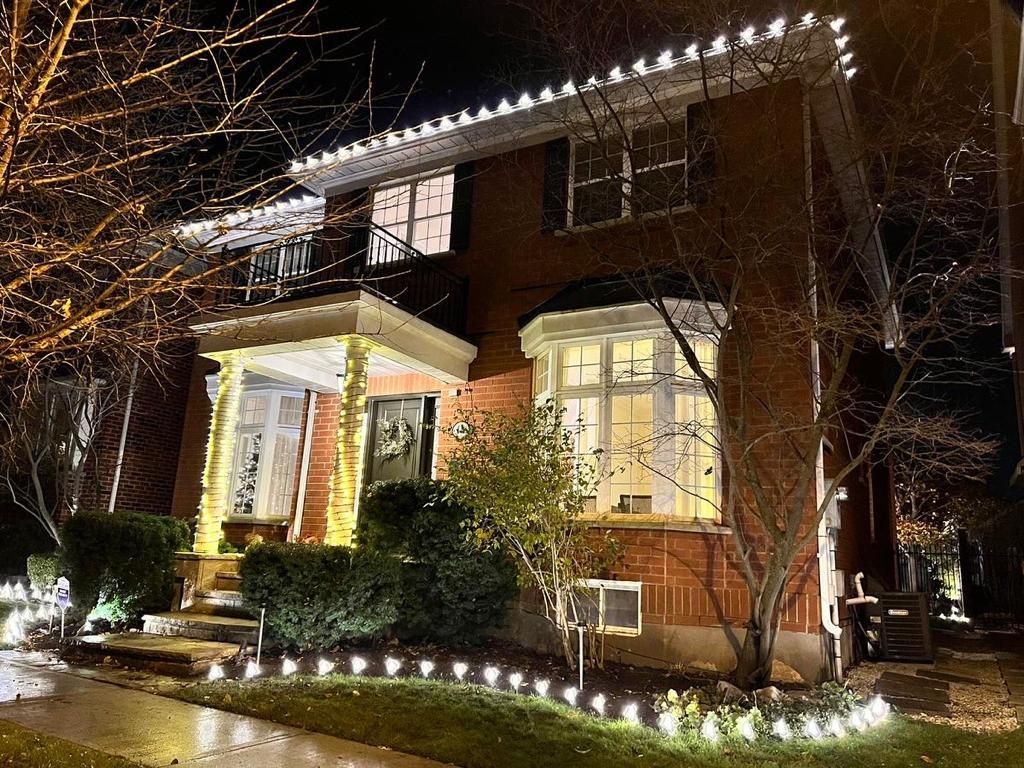 A house with christmas lights on it is lit up at night.