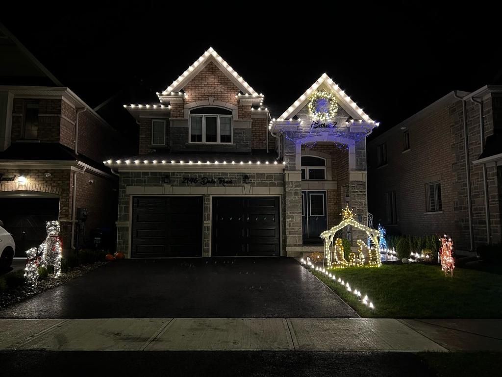 A large house is decorated with christmas lights at night.