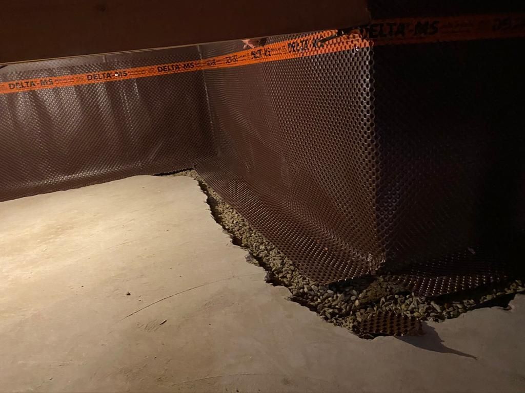 A corner of a basement with a drainage membrane on it.