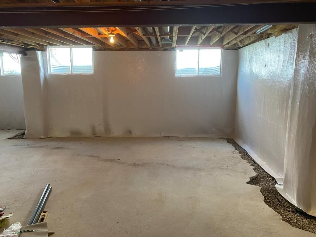 A basement with a lot of windows and a concrete floor.