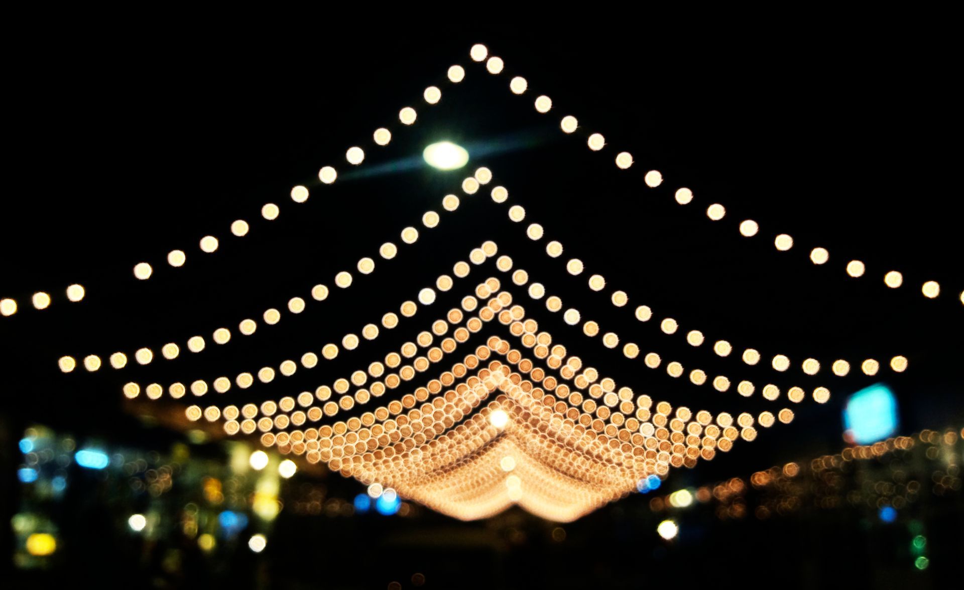 A bunch of lights are hanging from the ceiling at night.
