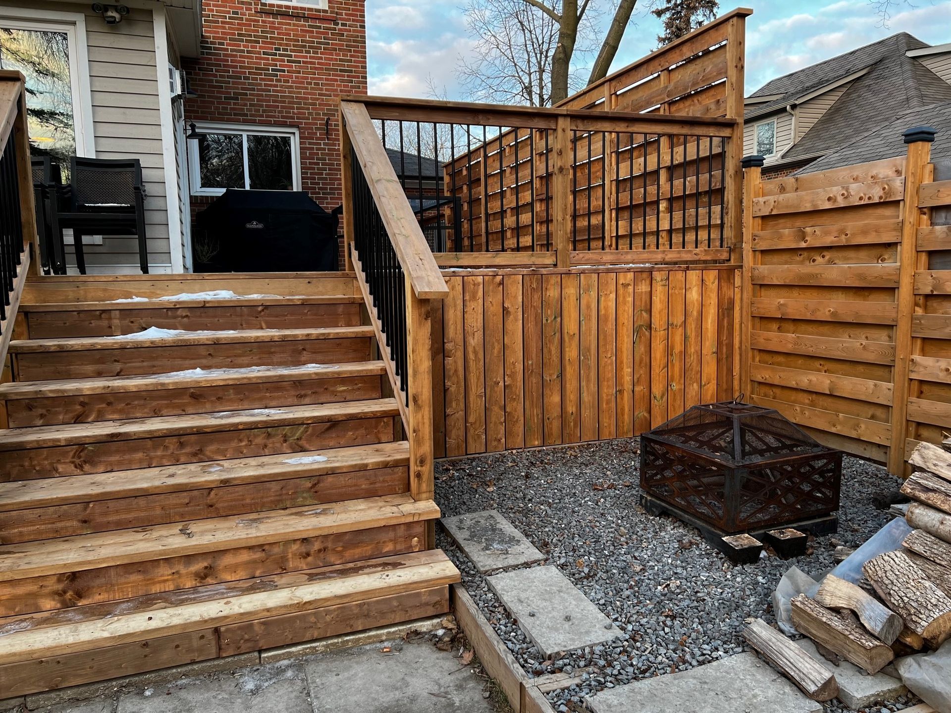 A wooden deck with stairs leading up to it and a wooden fence.