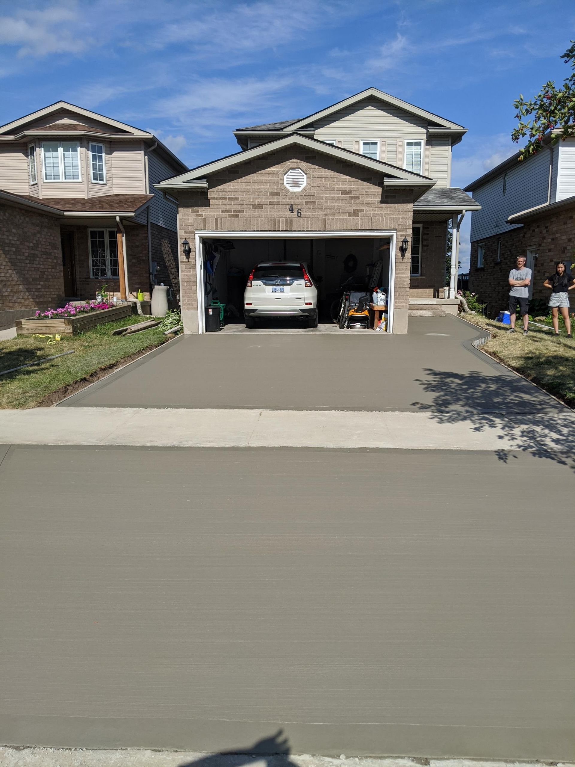 A car is parked in a garage in front of a house.