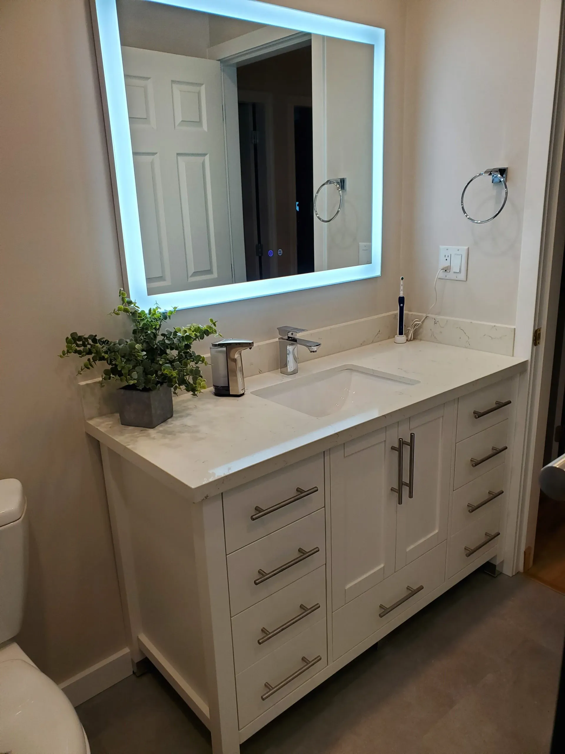 A bathroom with a sink , mirror and toilet.