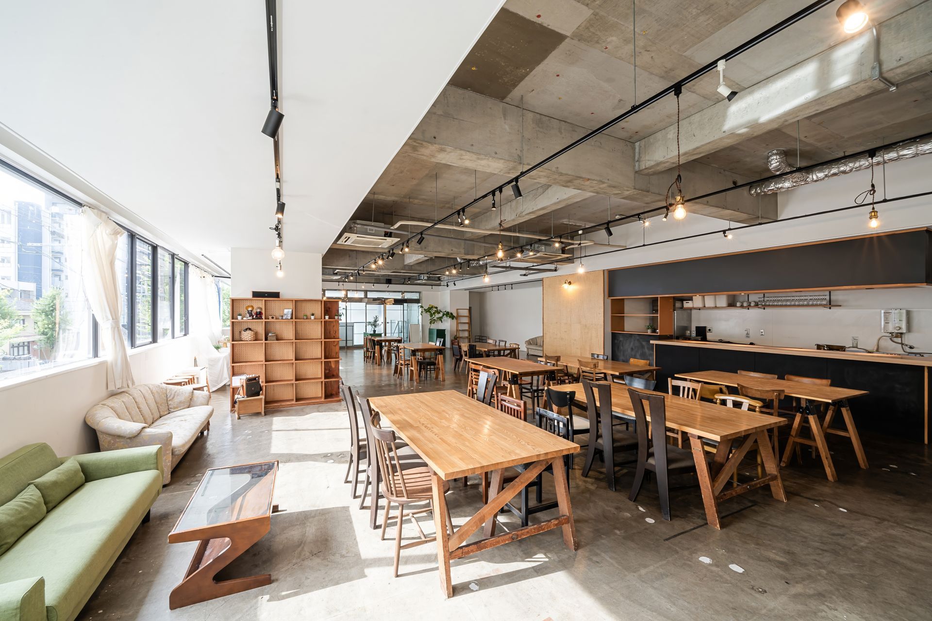 A large room with tables and chairs and a couch.