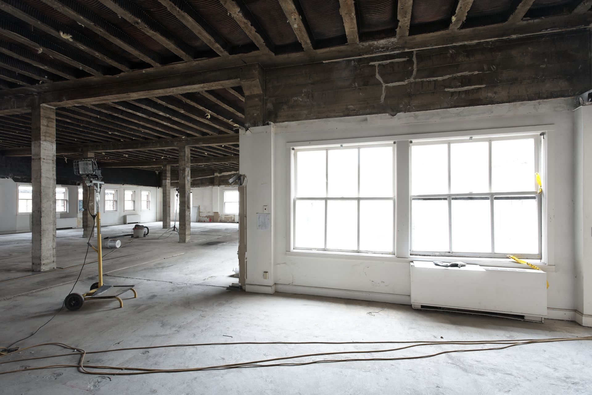 An empty room with a lot of windows and wooden beams