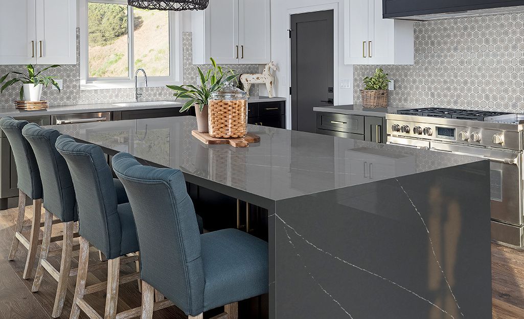 A kitchen with a large island and blue chairs.