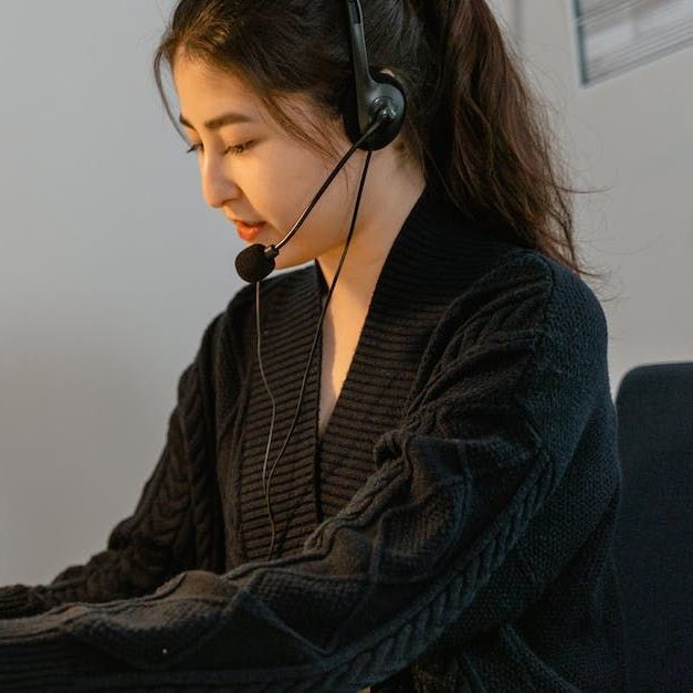 Image of a Woman wearing a headset doing office work at Overseas Filipino Workers