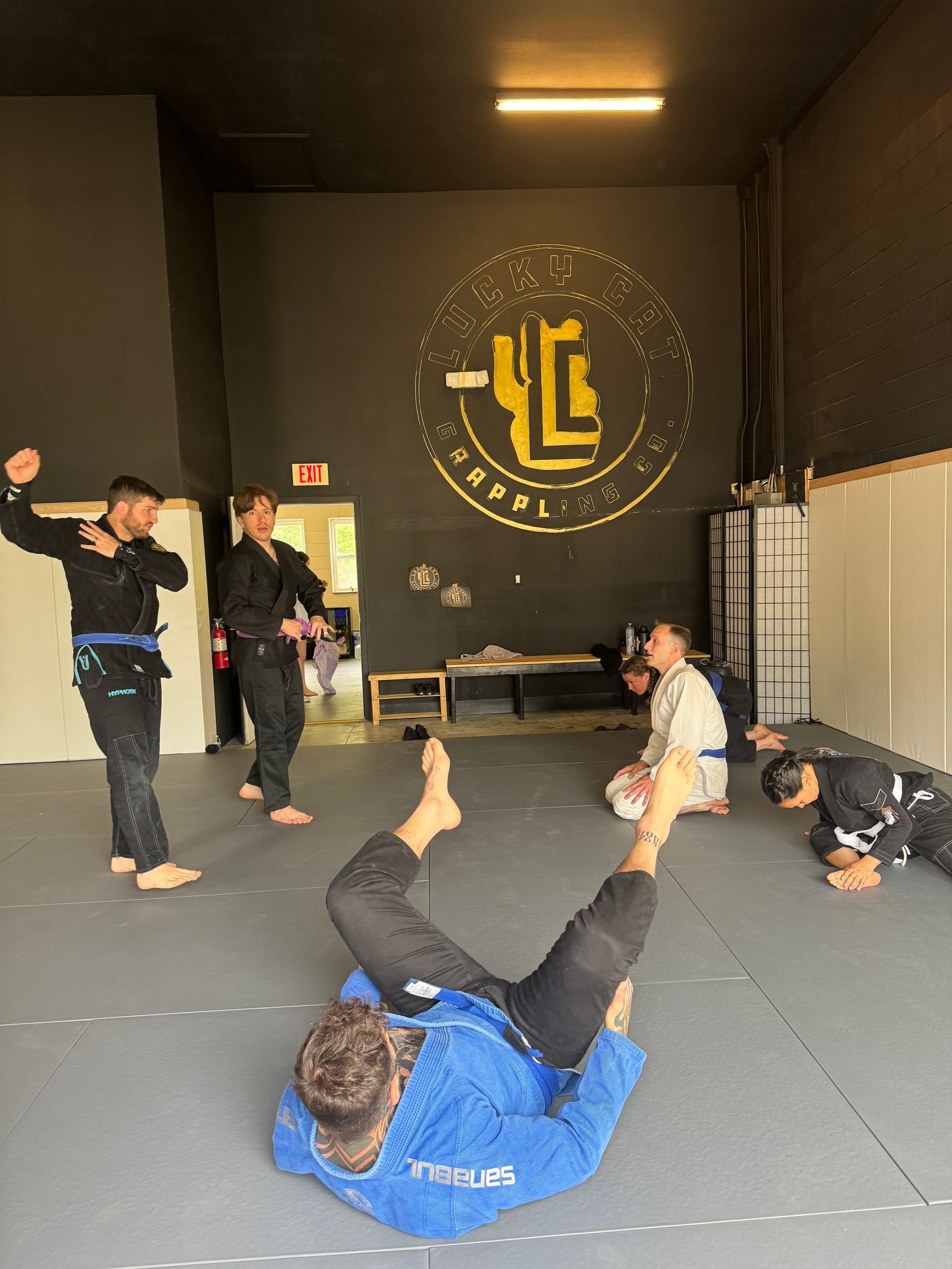 Athlete practicing solo Jiu Jitsu hip escapes at Lucky Cat Grappling Co. in Manalapan, NJ.