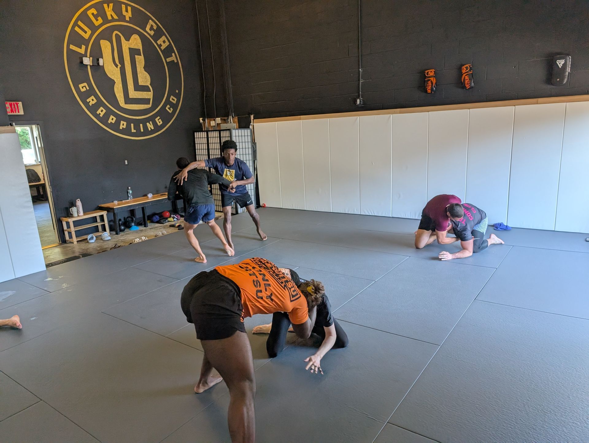 Beginner students practicing controlled grappling at Lucky Cat Grappling Co. in Manalapan, NJ to build confidence