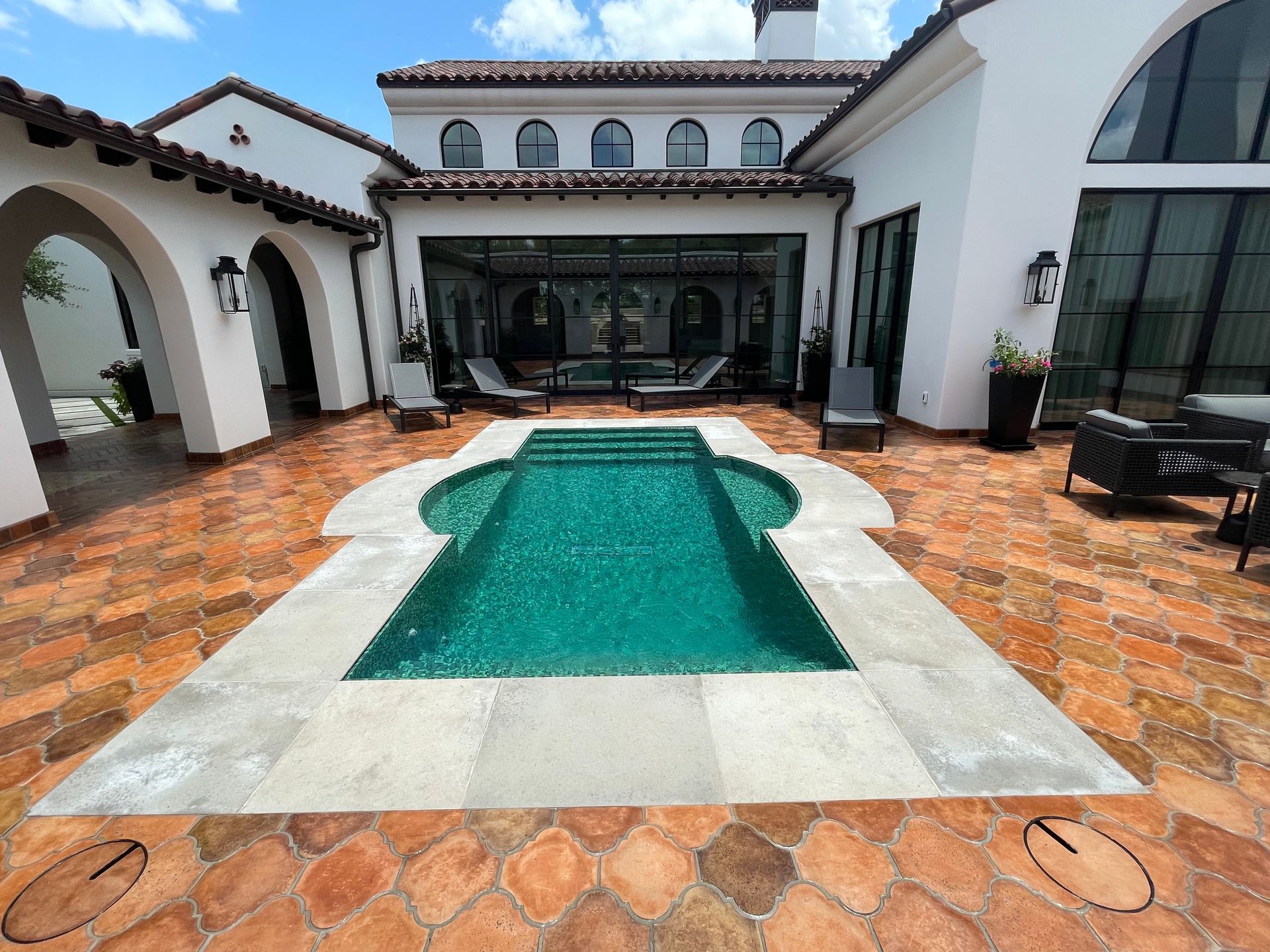 A large swimming pool in the backyard of a house.