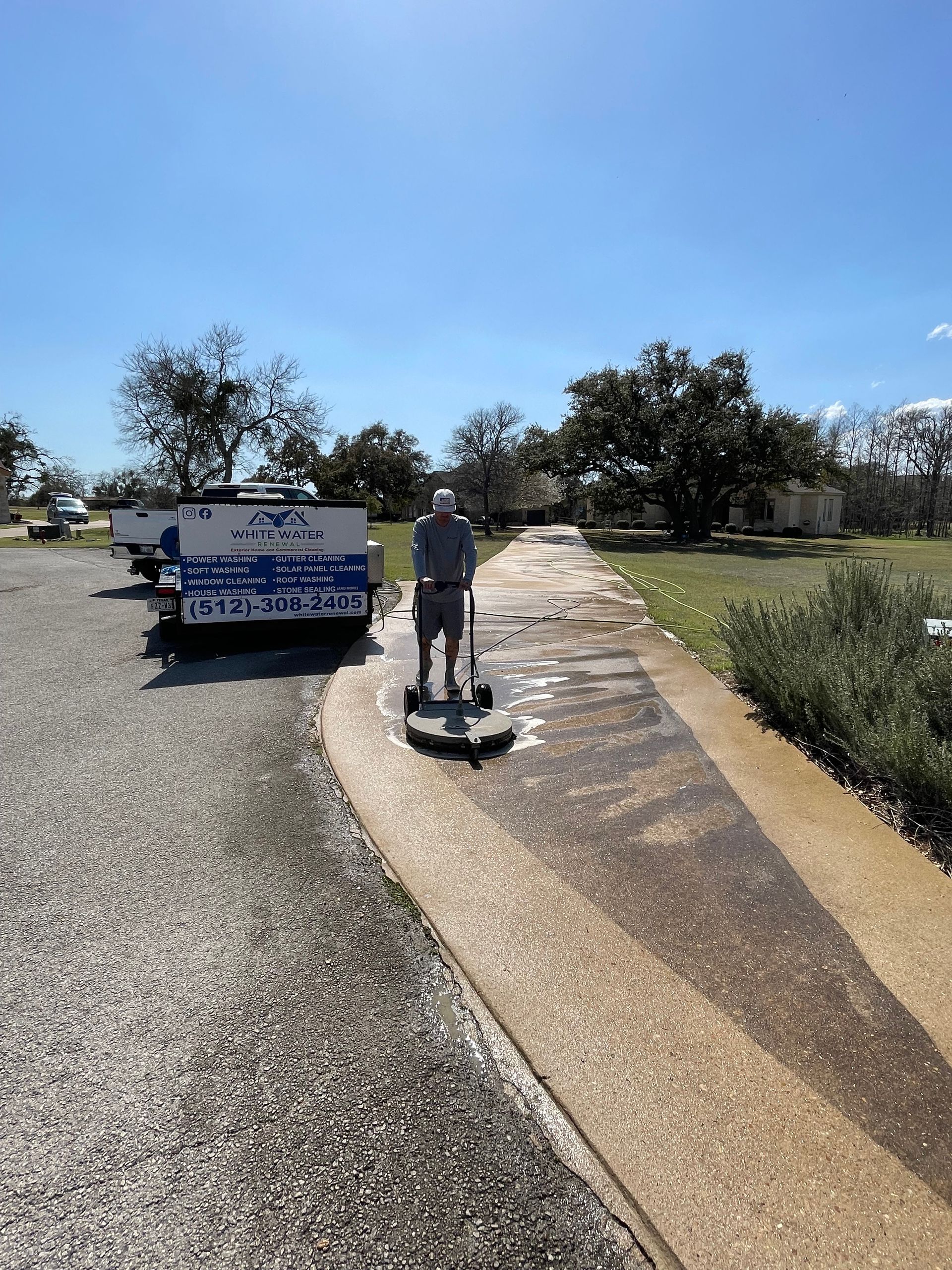 A man in green and yellow cleaning stairs with a hose