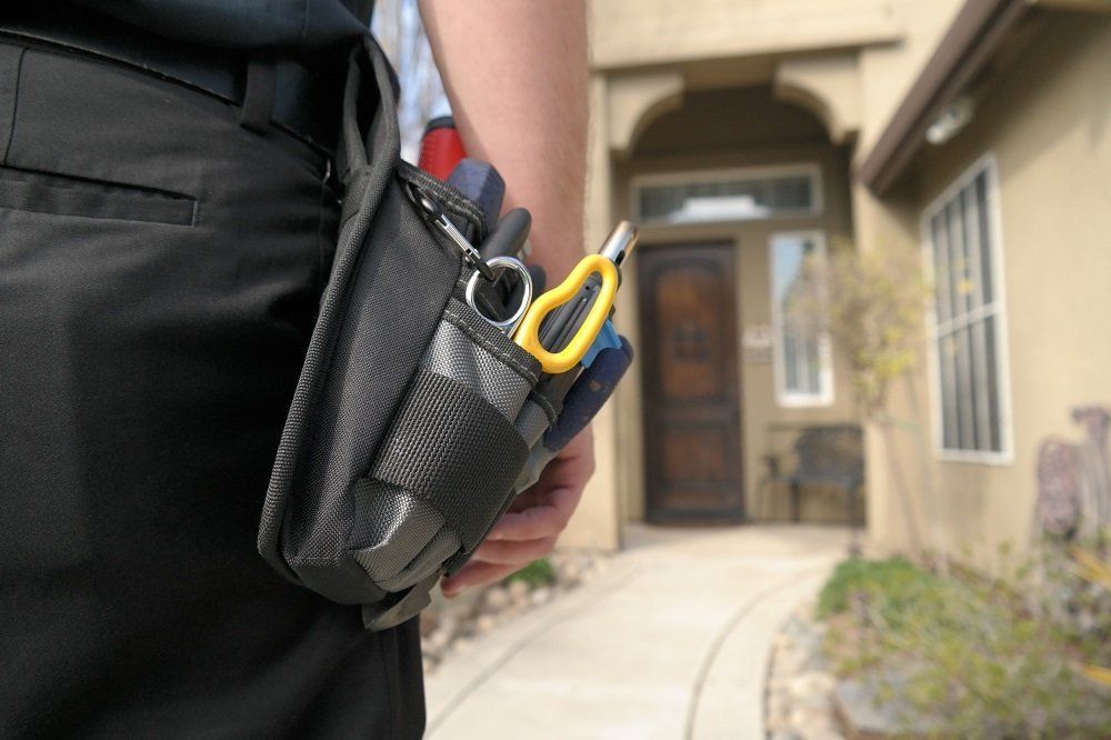 Man Holding Phone Inside A Car — Lodi, CA — Alamo Alarm Company Inc.