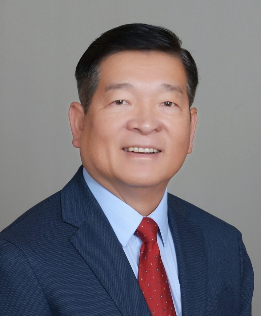 A man in a suit and tie is smiling for the camera