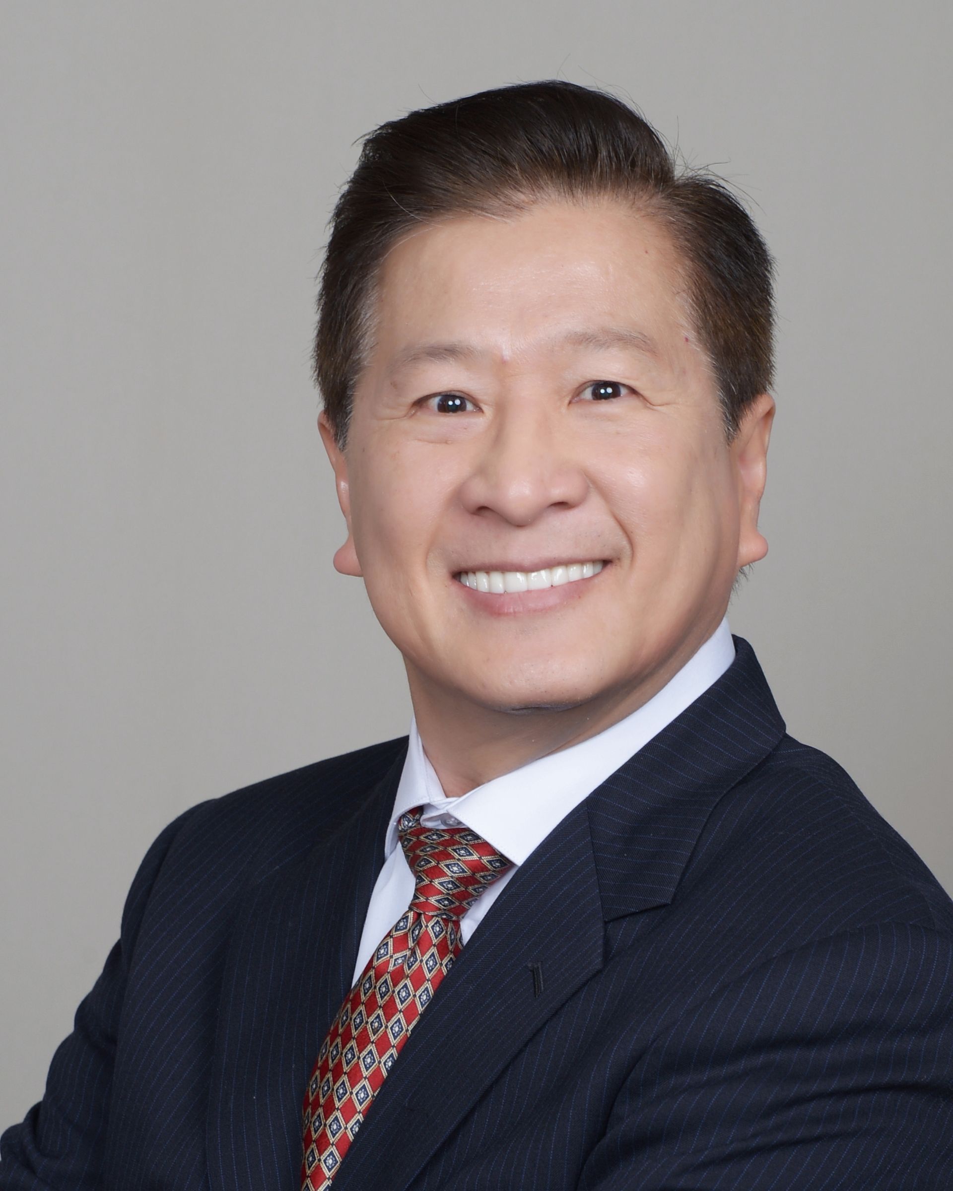 A man in a suit and tie is smiling for the camera.