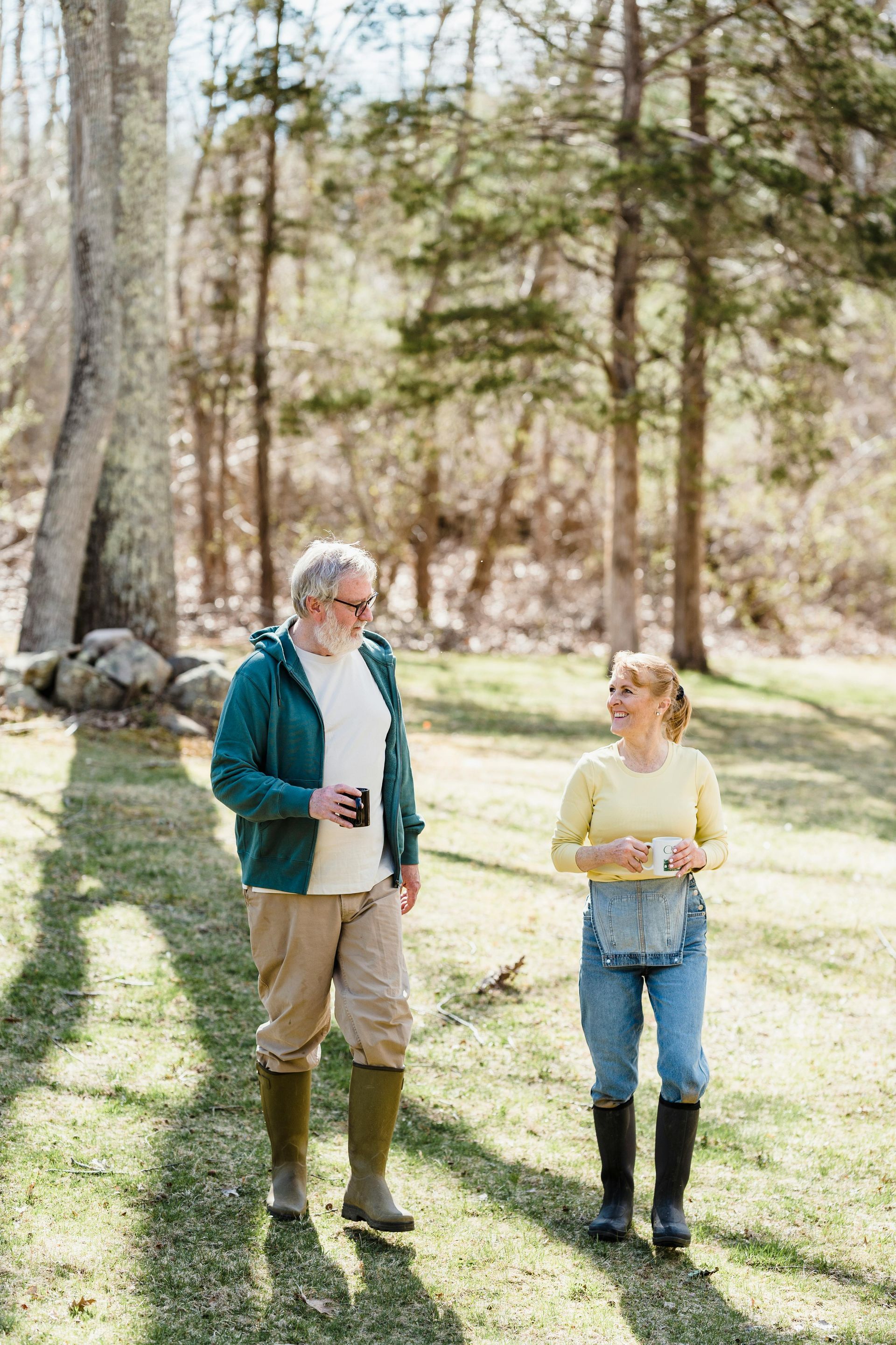 A man and a woman are walking in the woods.