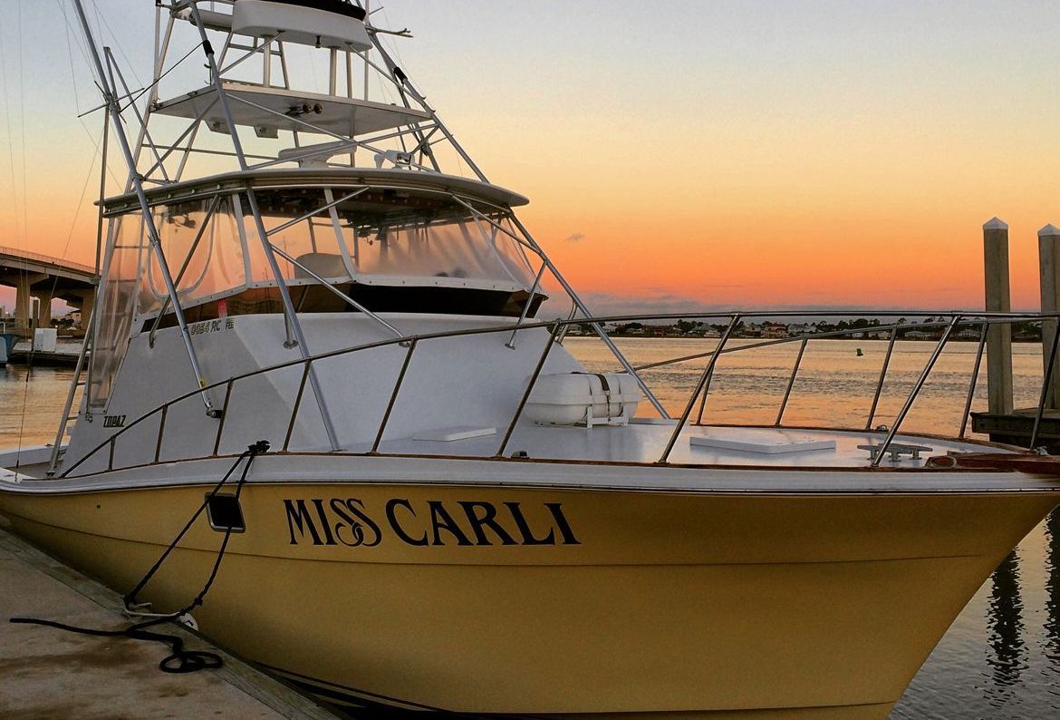 A yellow boat with the name miss carli on it