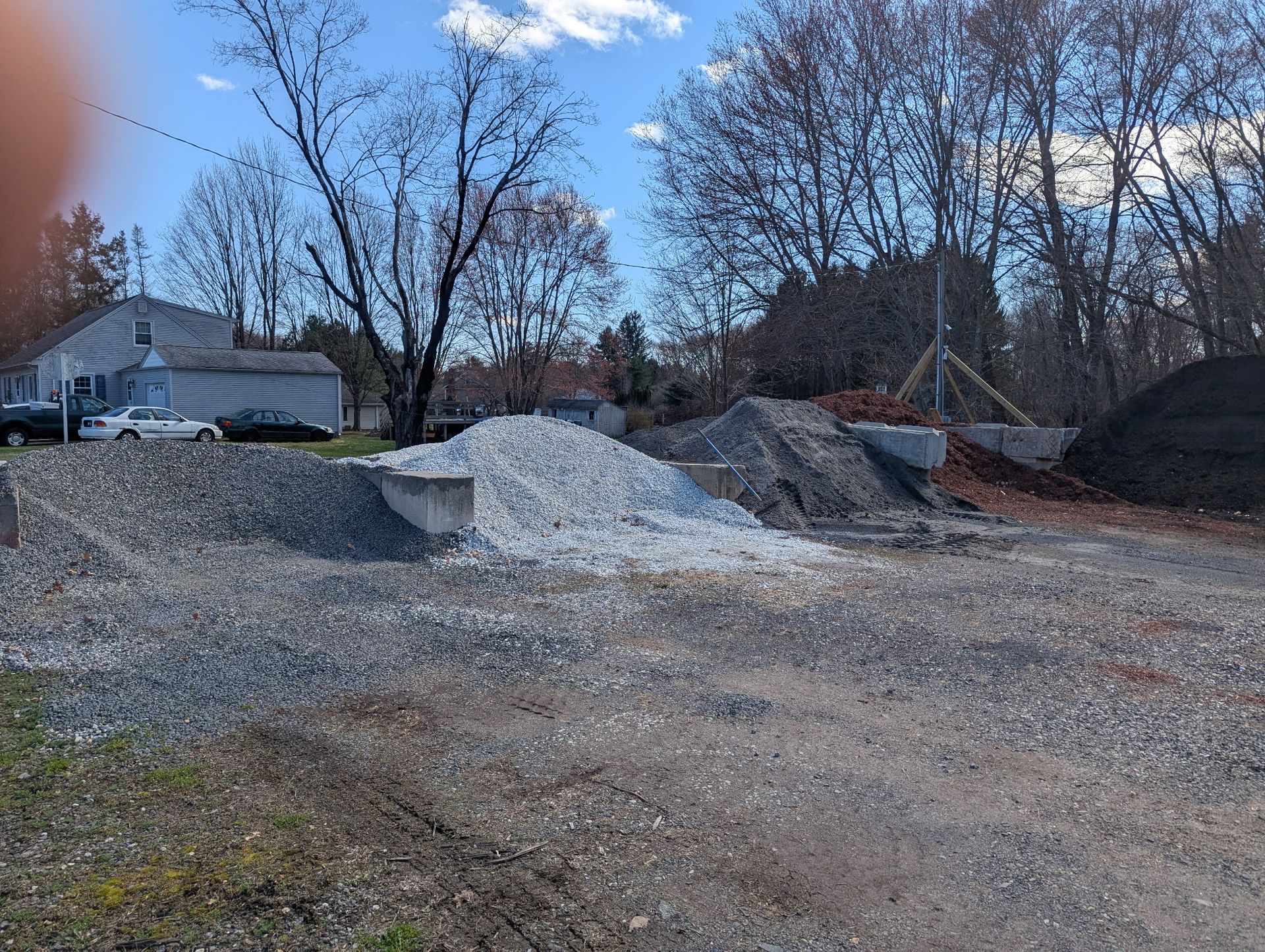 A pile of gray crushed gravel transitioning into a flat bed of tan sand.