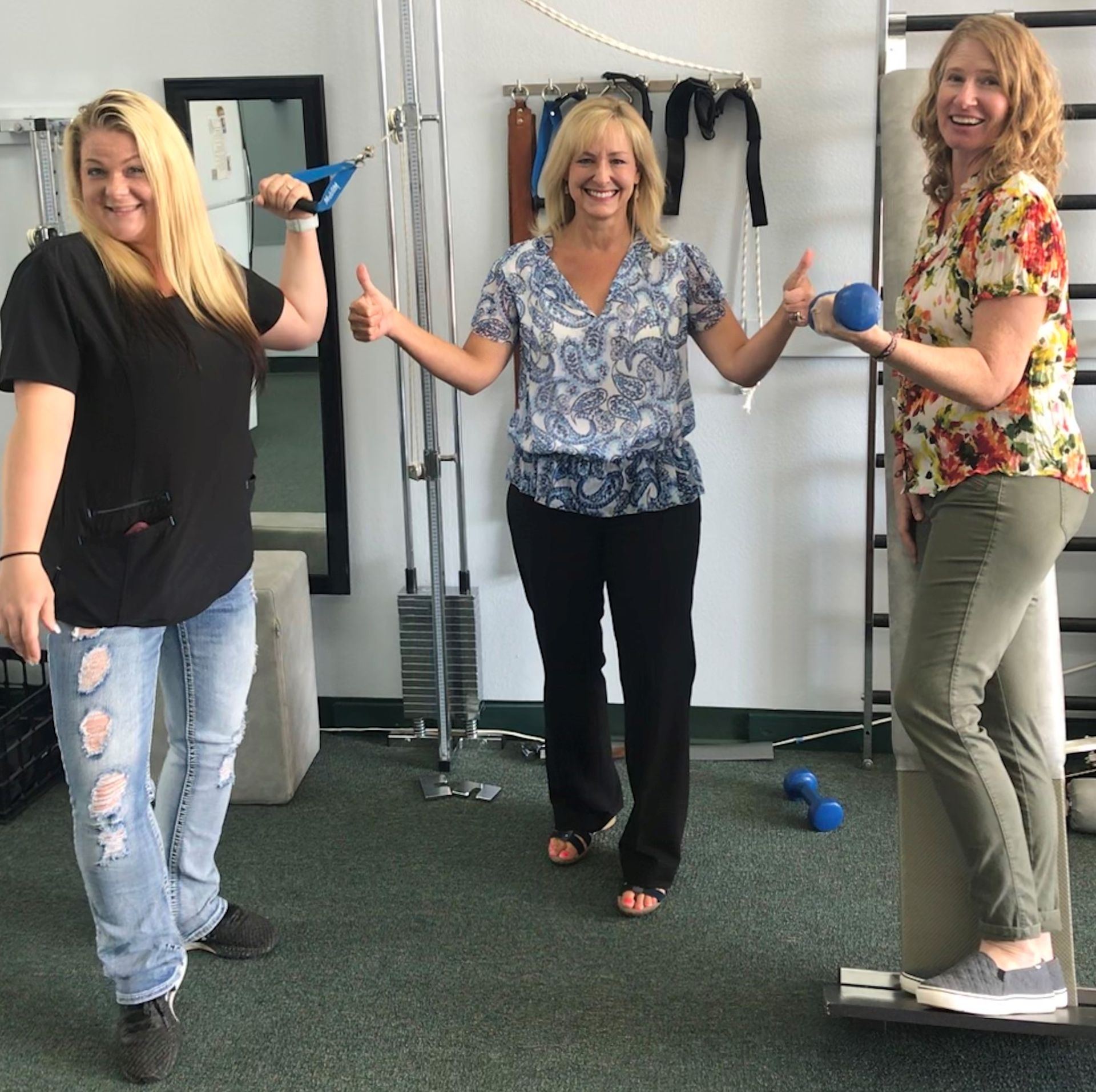 Colorful mosaic stone by a tree, surrounded by pink, white, red, and orange flowers in a garden bed