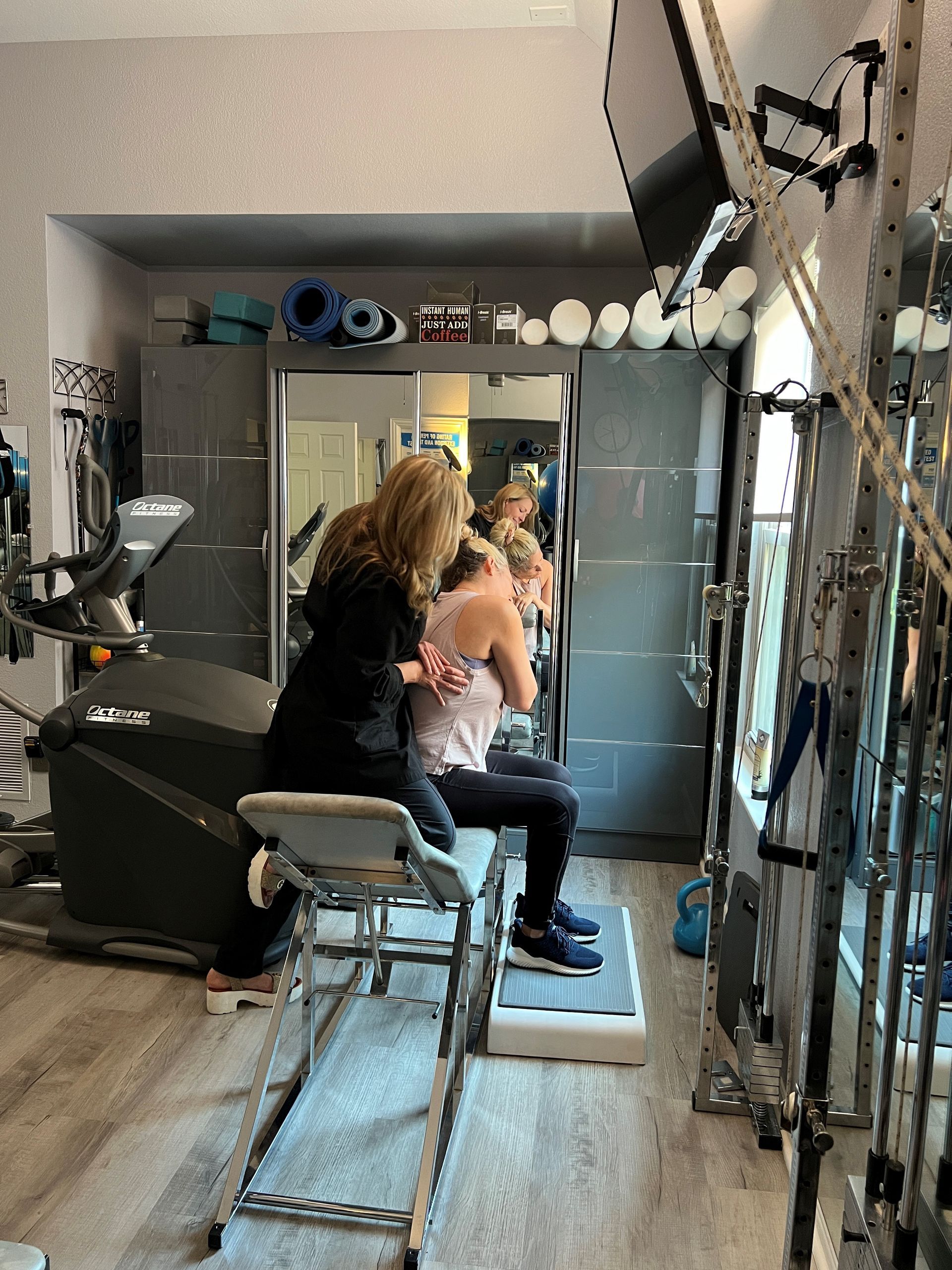 A woman is giving a man a massage in a gym.