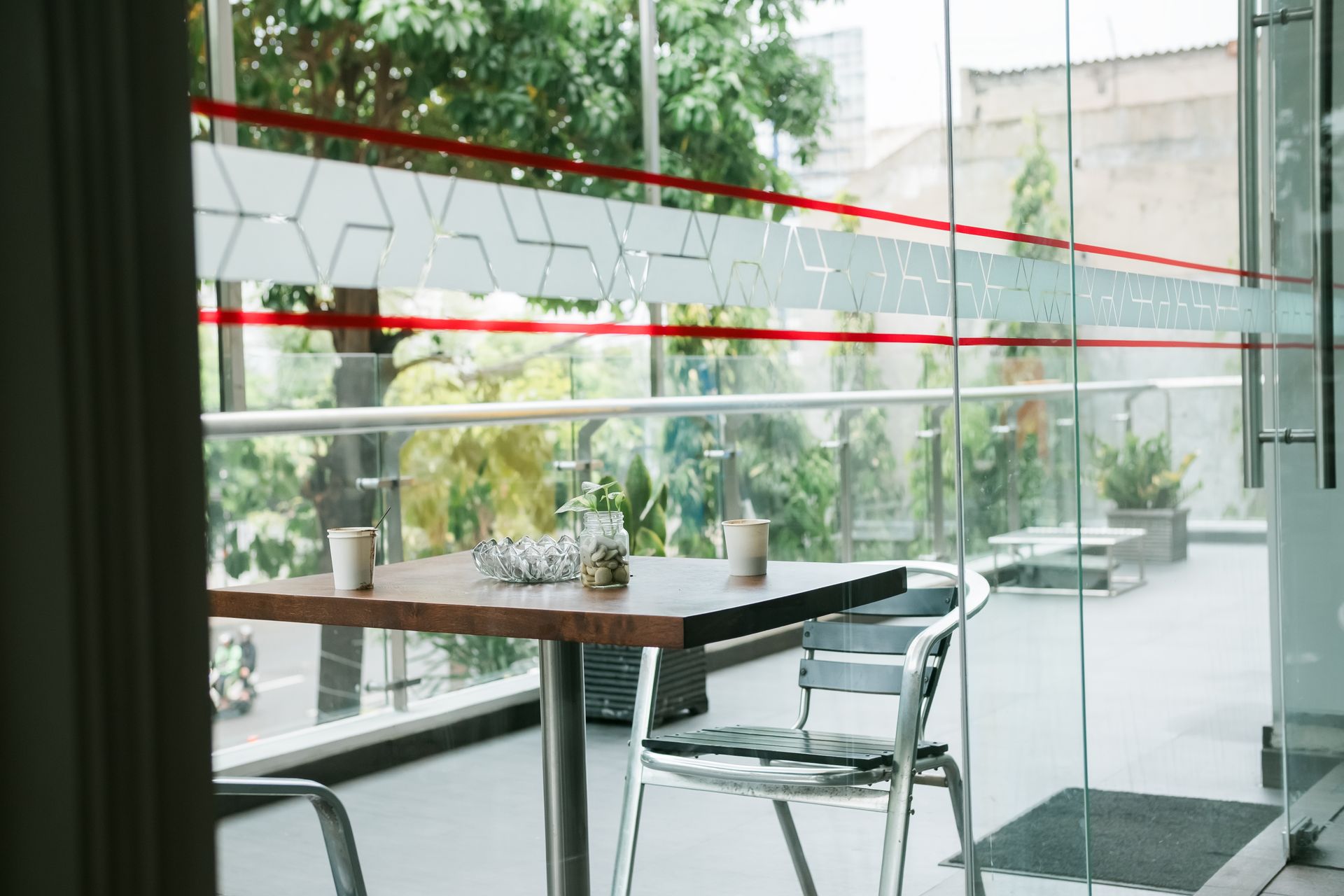 A table and chairs are sitting in front of a glass wall.