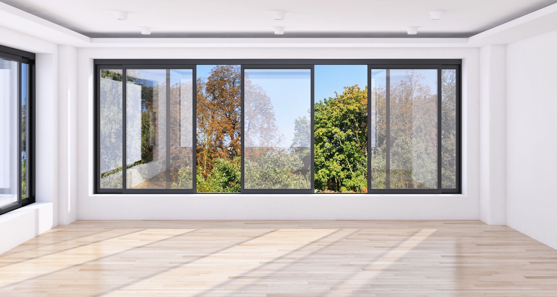 An empty room with a lot of windows and a wooden floor.