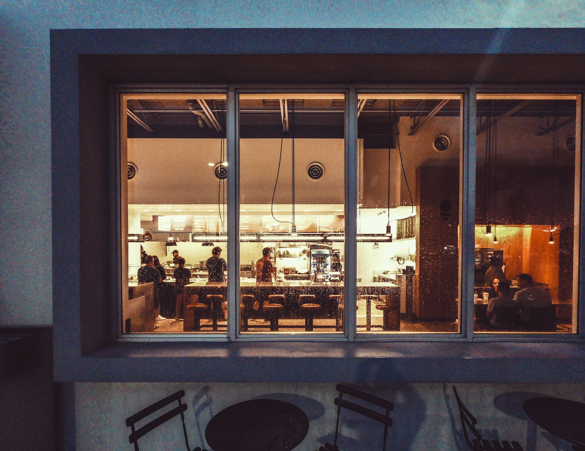 The inside of a restaurant is seen through a large window