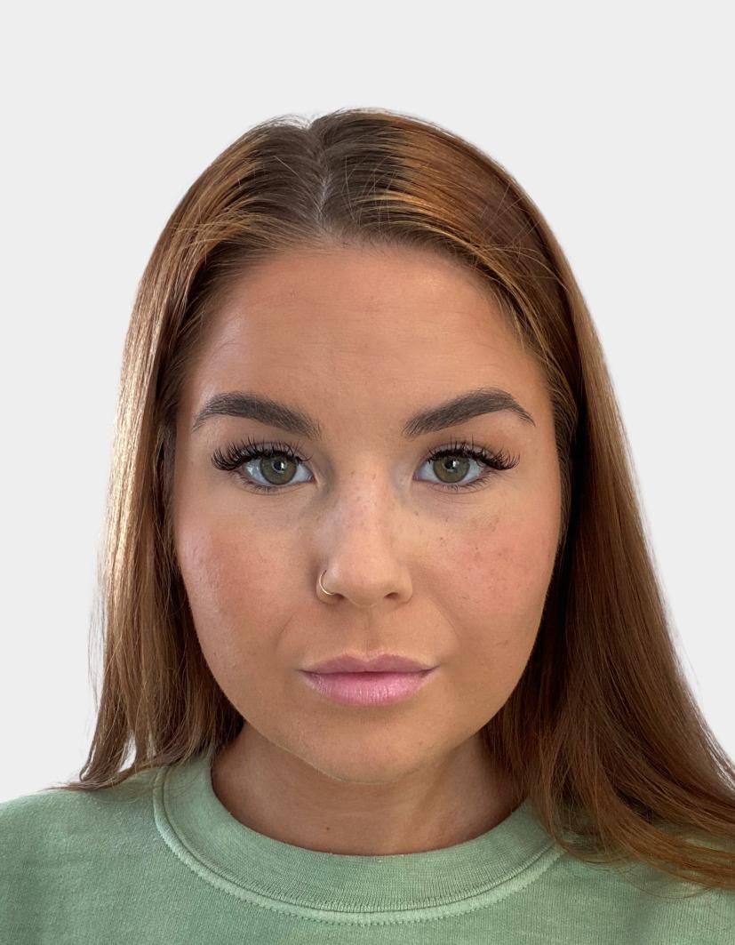 Woman with light brown hair and a light green shirt, looking forward with a neutral expression.