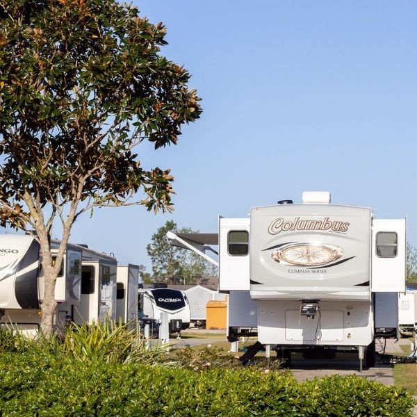 A white columbus rv is parked in a campground