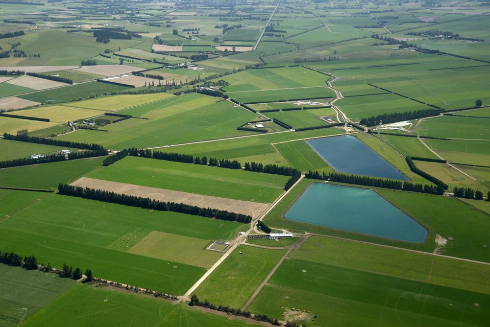 An Aerial View of a Lush Green Field With a Small Pond in the Middle — Jeff Thompson Excavator Hire Pty Ltd In Pink Lily, QLD